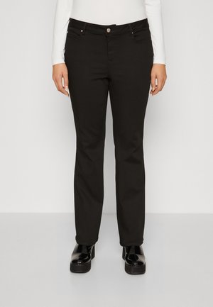 Jean noir avec une coupe droite, en denim, doté de matériel en métal et de poches avant. Assortis à des chaussures à plateforme noires brillantes.