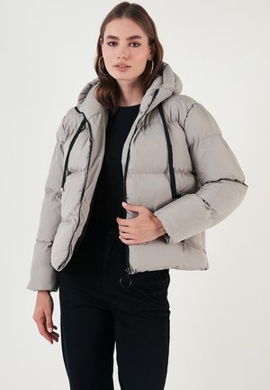 Light gray puffer jacket with a hood, featuring a front zipper, black drawstrings, and a boxy cut. Smooth, quilted texture.