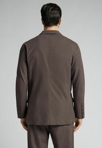 Braune taillierte Blazerjacke mit glatter Textur, einem Reverskragen und Knopfmanschetten mit fünf Knöpfen, entworfen für eine strukturierte Passform.