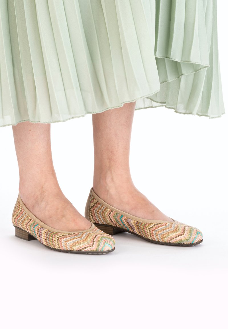 Geflochtene Stoffschuhe mit einem Chevron-Muster in Beige, Pink, Grün und Blau, mit einem niedrigen Holzabsatz und einem abgerundeten Zehenbereich.