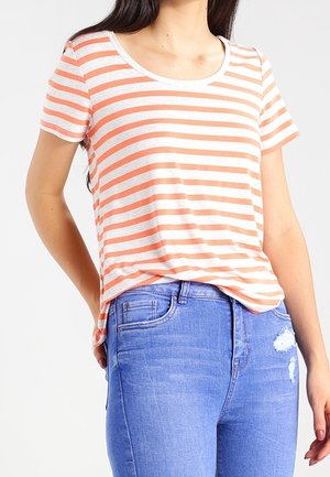 Striped short-sleeve t-shirt features light gray and peach horizontal stripes, round neckline, and relaxed fit, paired with blue denim jeans.