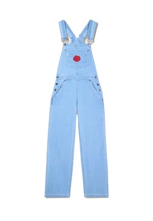 Salopette in denim azzurro chiaro con bretelle regolabili, due tasche frontali e una tasca posteriore con un patch circolare rosso. Dettagli in metallo argentato.
