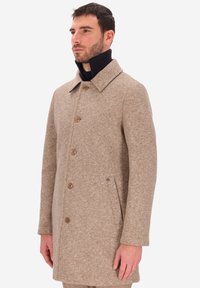 Cappotto di lana beige con motivo a spina di pesce, colletto a rever, sei bottoni e tasche laterali. Tessuto morbido e vestibilità su misura.