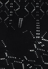 Collant neri in pizzo con intricate fantasie a diamante e pois. Presentano una texture morbida e un aspetto lavorato a maglia, che aumenta la profondità visiva.