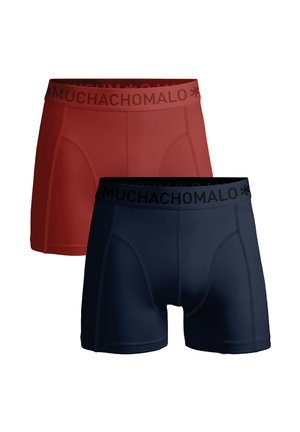 Piros és sötétkék boxer nadrág fekete derékkal, amelyen a "MUCHACHOMALO" felirat található. Simakészségű, rugalmas anyagból készült, szűk szabással.