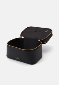 Bolso de cosméticos negro hecho de material suave. Cierre de cremallera con detalles dorados, bolsillo interior, forma rectangular, diseño minimalista.