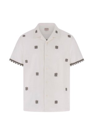 Chemise blanche à manches courtes avec boutons, ornée de motifs floraux noirs symétriques dispersés et d'une bordure à motifs sur les bords des manches.