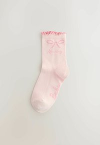 Svijetloružičaste čarape s naboranim rubovima, ukrašene grafikom mašne i riječju "Monday" u nježno ružičastoj boji. Glatka tekstura, materijal od mješavine pamuka.