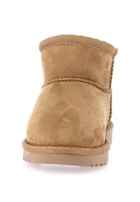 Stivaletti alla caviglia in suede beige con punta rotonda, upper morbido e suola testurizzata con cuciture decorative lungo le cuciture.