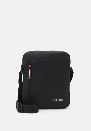 Sac bandoulière rectangulaire noir avec poche avant zippée, bandoulière réglable et logo "HILFIGER" blanc en bas à droite.