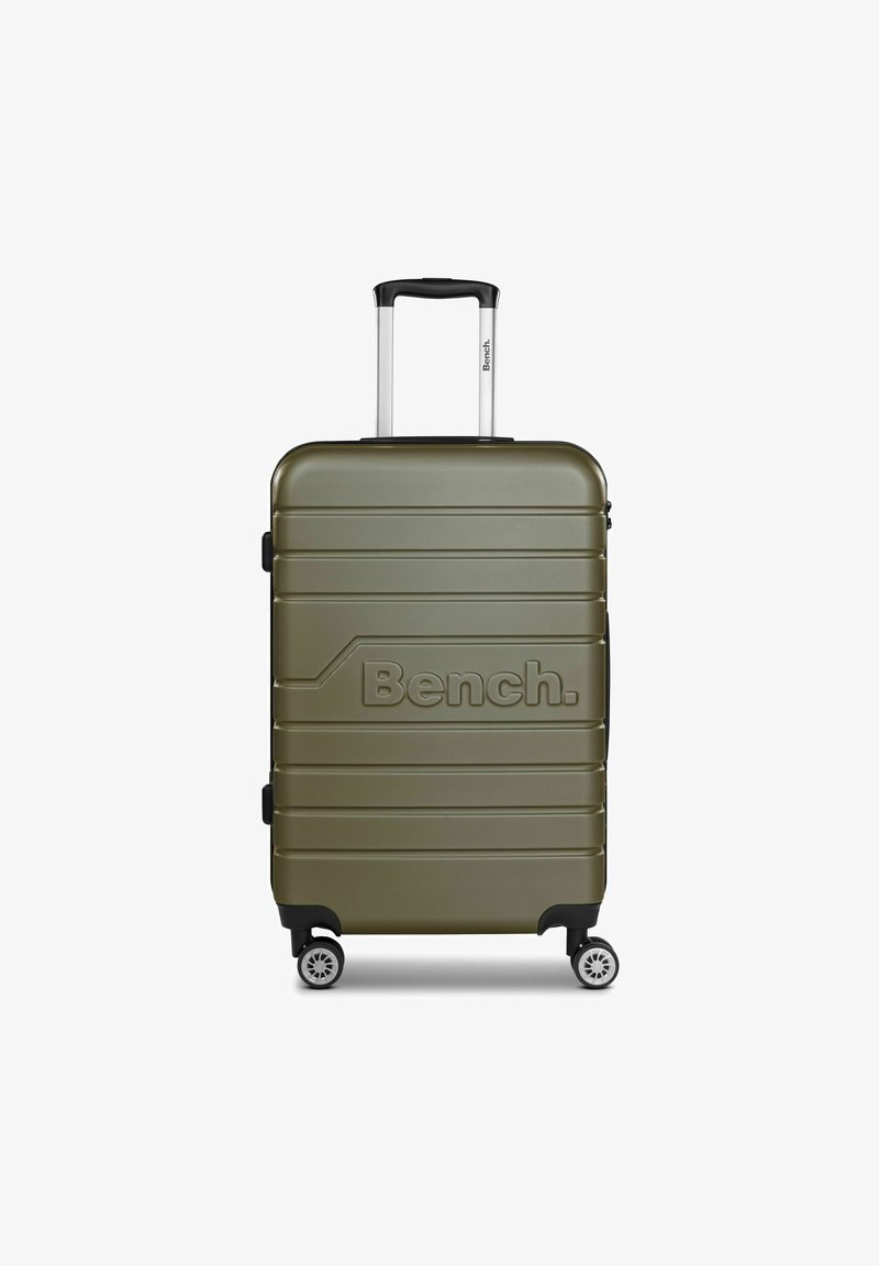 Maleta dura verde con superficie estriada, logo en relieve, asa retráctil y cuatro ruedas para una fácil movilidad.