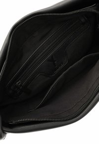 Mustan nahkalaukun sisus, jossa on vetoketjullinen tasku, sileä kankainen vuori ja erottuva ommel. Vetoketjusulkeminen ylhäällä.