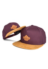 Gorra marrón con visera de ante color miel, con un parche de cuero marrón grabado con "BLACKSKIES" y pequeños detalles de diseño.