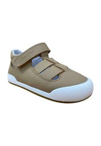 Zapato de cuero marrón con correa de velcro y diseño recortado, suela de goma blanca y puntera texturizada. Presencia de costuras mínimas y detalles de marca.