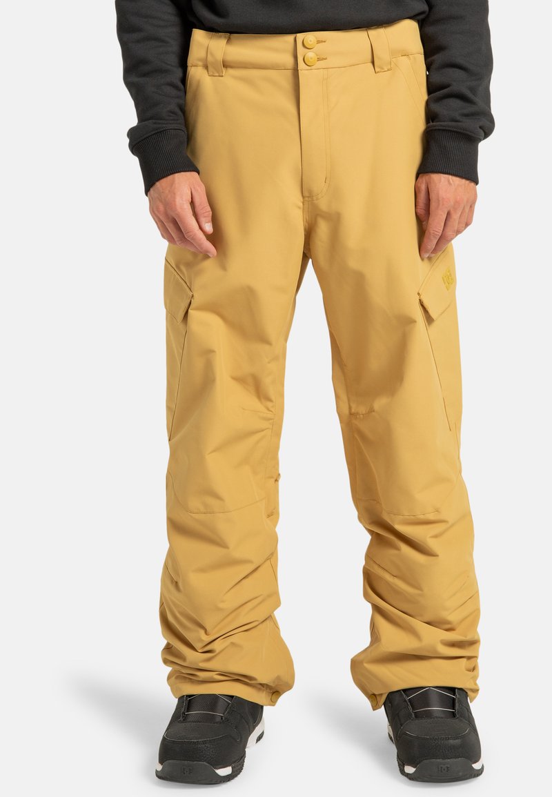 Pantaloni da neve gialli impermeabili con vestibilità ampia, dotati di tasche cargo e chiusura a due bottoni. Tessuto testurizzato, progettato per l'uso all'aperto.