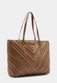 Borsa tote in pelle marrone trapuntata con due manici, caratterizzata da un motivo a zigzag e un logo discreto. Texture liscia, design robusto.
