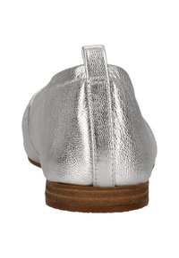 Silberne Lederballerinas mit einer strukturierten Oberfläche, flachem Absatz und einem kleinen Anhänger hinten für einfaches Anziehen. Die braune Sohle steht im Kontrast zum Obermaterial.