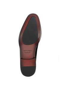 Schuhsohle mit glatter schwarzer Gummisohle und braunem Lederobermaterial, mit Naht und einem Logolabel, für Langlebigkeit konzipiert.