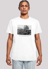White T-shirt featuring a black and white graphic of the Batmobile with two figures. The design includes the text "BATMOBILE" below the image.