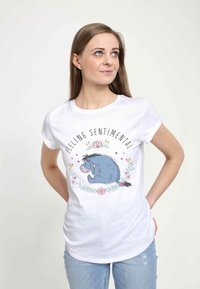 Bílý tričko s barevným motivem Eeyora, květinami a textem "Cítím se nostalgicky." Měkký materiál, slim-fit střih.