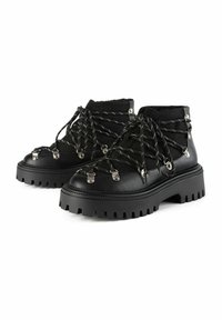 Botas negras de tobillo con material texturizado, suela de goma gruesa y hardware metálico. Presentan cordones cruzados y un diseño de suela resistente para mejorar la tracción.