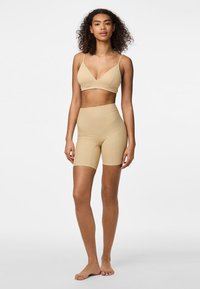 Bézs seamless bralette és magas derekú sort, puha textúra, rugalmas anyag, minimalista dizájn, állítható pántok, térdhez érő sort.