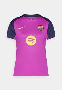 Lilla Nike-drakt med marineblå ermer, prydet med en gul Spotify-logo og FC Barcelona-emblem på brystet. Pustende stofftekstur.