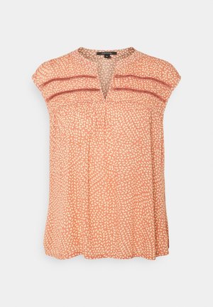 Blouse corail sans manches avec motif de feuilles crème, détail en dentelle sur la poitrine et petite ouverture en V.