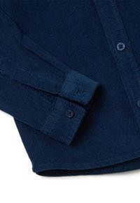 Donkerblauwe corduroy overhemd met een button-down kraag, lange mouwen met knoopmanchetten en subtiele ribbelstructuur.
