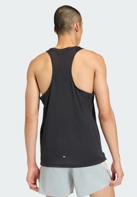 Black sleeveless athletic tank top with racerback design. Soft, moisture-wicking fabric. Features subtle logo at the hem for branding.