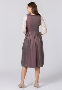 Langes lila Kleid mit einem plissierten Rock, einem taillierten Oberteil und einem strukturierten Taillengürtel, ergänzt durch ein langärmliges Oberteil aus Spitze.