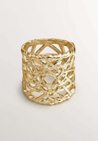 Anillo de oro tejido con un diseño abierto, que presenta hilos texturizados y un patrón geométrico único. El acabado suave realza su estructura.