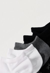 Neljä paria lyhyitä sukkia valkoisina, harmaina ja mustina. Resorissa raitakuviot ja vaihtelevat värikuviot.