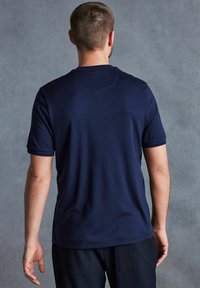 Donkerblauw T-shirt met korte mouwen, gemaakt van gladde stof, met een ronde hals, eenvoudig ontwerp en een relaxed fit, weergegeven vanuit de achterkant.