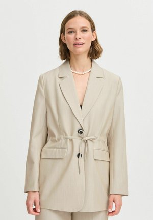 Blazer beige ajusté avec deux poches avant, une taille cintrée et fermeture à un bouton. Tissu lisse avec une texture verticale subtile.