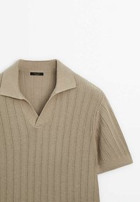 Polo à manches courtes en maille côtelée beige avec col ouvert et rayures verticales texturées.