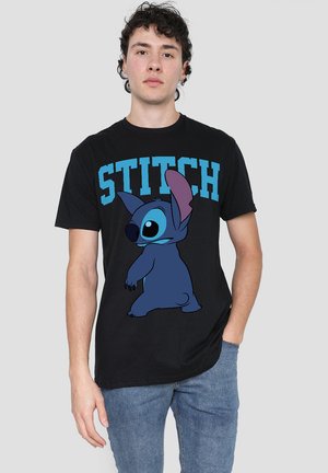 Black cotton t-shirt featuring a blue cartoon character, Stitch, with large ears and round eyes, alongside the text "STITCH" in bold blue letters.