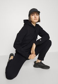 Champion BASIC CUFF PANTS - Träningsbyxor - black