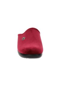 Scarpa slip-on in suede rosso con bordo superiore curvo, texture perforata e suola in gomma nera; presenta un piccolo logo metallico sul lato.