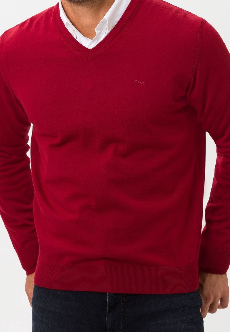 Pull-over rouge à col en V en tissu doux, avec manches longues et ourlet côtelé. Aucune motif ou détail métallique visible.