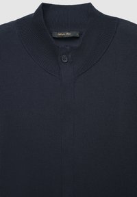 Marineblauer Cardigan mit geripptem Kragen, einem einzelnen Knopfverschluss, strukturiertem Stoff und einem Etikett, das die Größe L angibt.