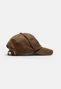 Brun bomuldsbaseballcap med en buet skygge, justerbar metalbagrem og synede detaljer på krone og skygge.