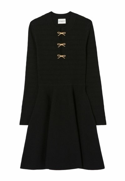 Abito lavorato a maglia nero a maniche lunghe con gonna svasata e tre piccoli bottoni a forma di fiocco dorato lungo il collo.