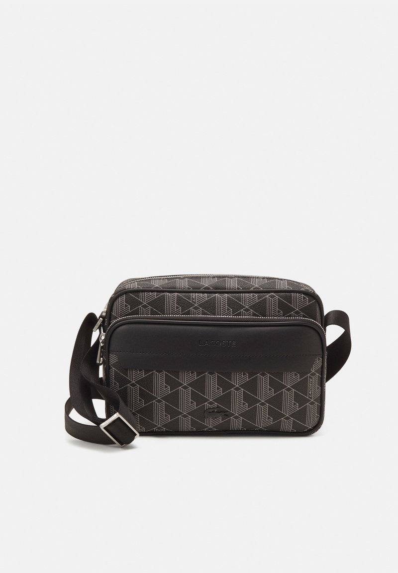 Czarna torba crossbody z geometrystycznym wzorem, z gładką panelem z czarnej skóry, z zapięciem na suwak i regulowanym paskiem. Posiada logo marki z przodu.