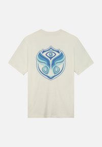 Katoenen t-shirt in off-white met een blauw grafisch ontwerp op de achterkant, met gestileerde elementen die lijken op een masker of embleem.