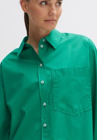 Groene button-up shirt van gestructureerd katoen. Bevat een puntige kraag, een borstzak en ronde knopen. Glad textuur en relaxte pasvorm.