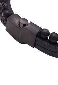 Zwarte leren armband met ronde zwarte kralen en een metalen sluiting. Het ontwerp bevat textuurdetails en een gladde afwerking.