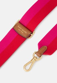 Bawełniany pasek z czerwonymi i fuksjowymi paskami, z brązową skórzaną naszywką oznaczoną napisem "kate spade" oraz klipsem z metalowym wykończeniem w kolorze złotym.