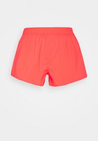 Bañador de color coral neón con cinturilla elástica, de longitud media hasta el muslo y tejido suave, apoyado sobre un fondo blanco.