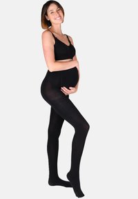 Sorte graviditetstights med en glat overflade og høj talje, tæt design der dækker benene helt, parret med en simpel sort bralette.